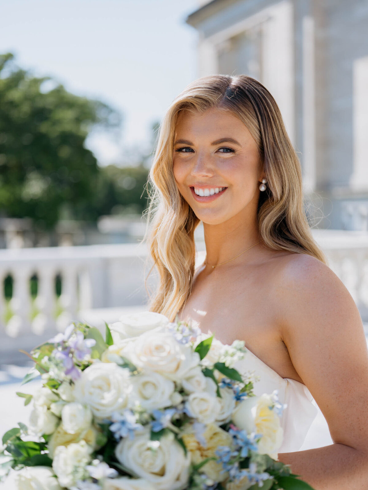 Bride up close with her large bouquet with white and blue