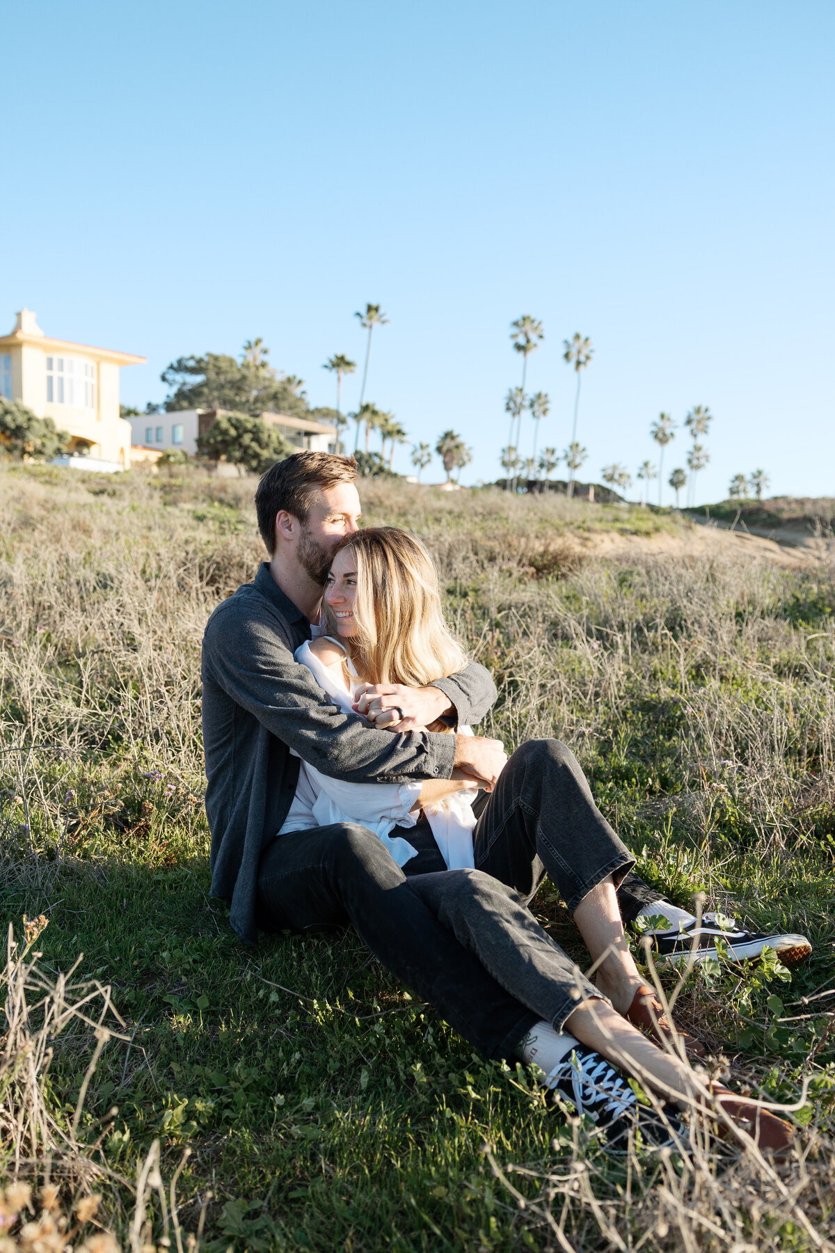 Beautiful sunset engagement photo of the couple on a cliffside, perfectly lit by a Southern California wedding photographer.