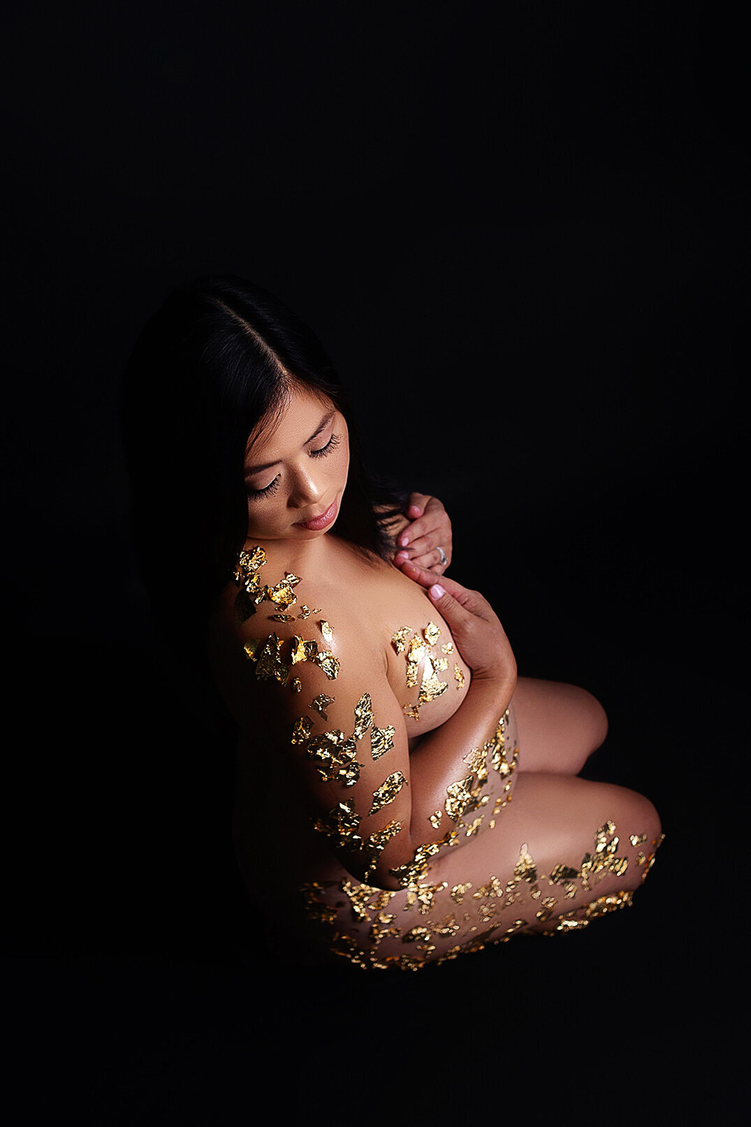 Women posing nude with gold foil on pregnant belly during maternity photoshoot in Mount Juliet tennessee photography studio