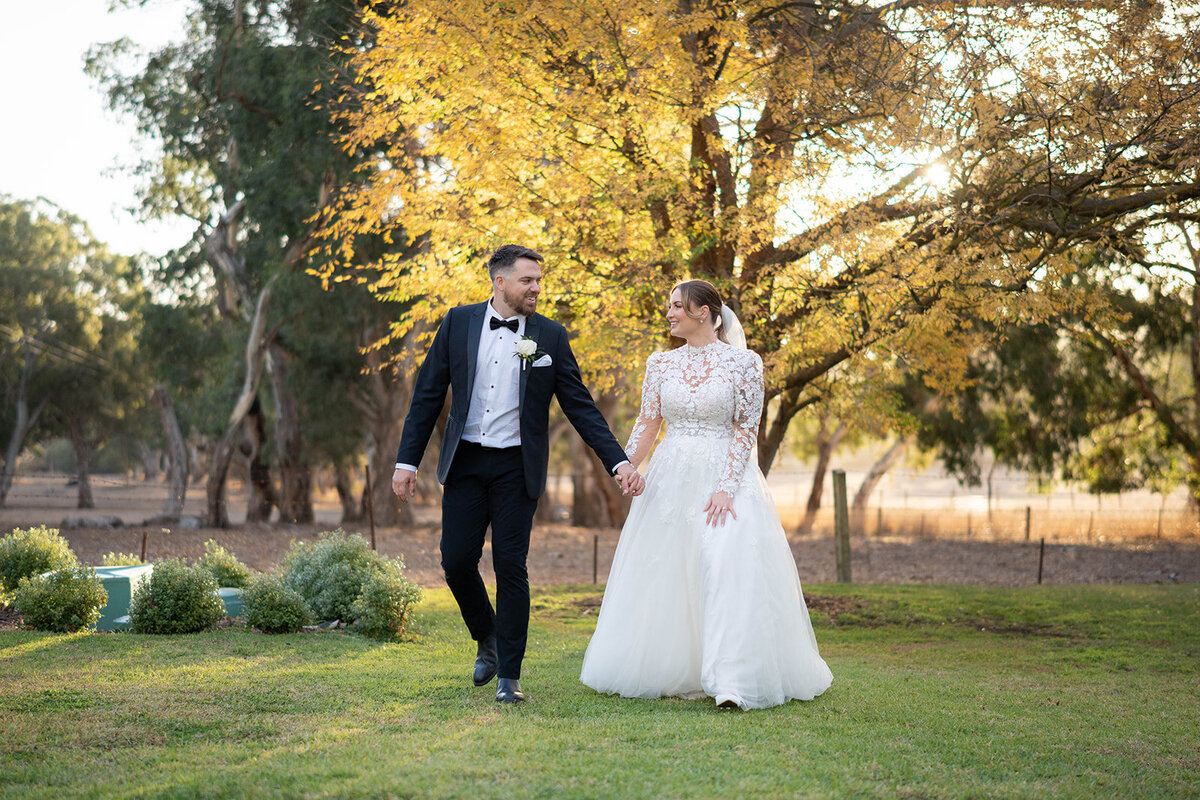 Newlyweds laughing together in a sunlit garden