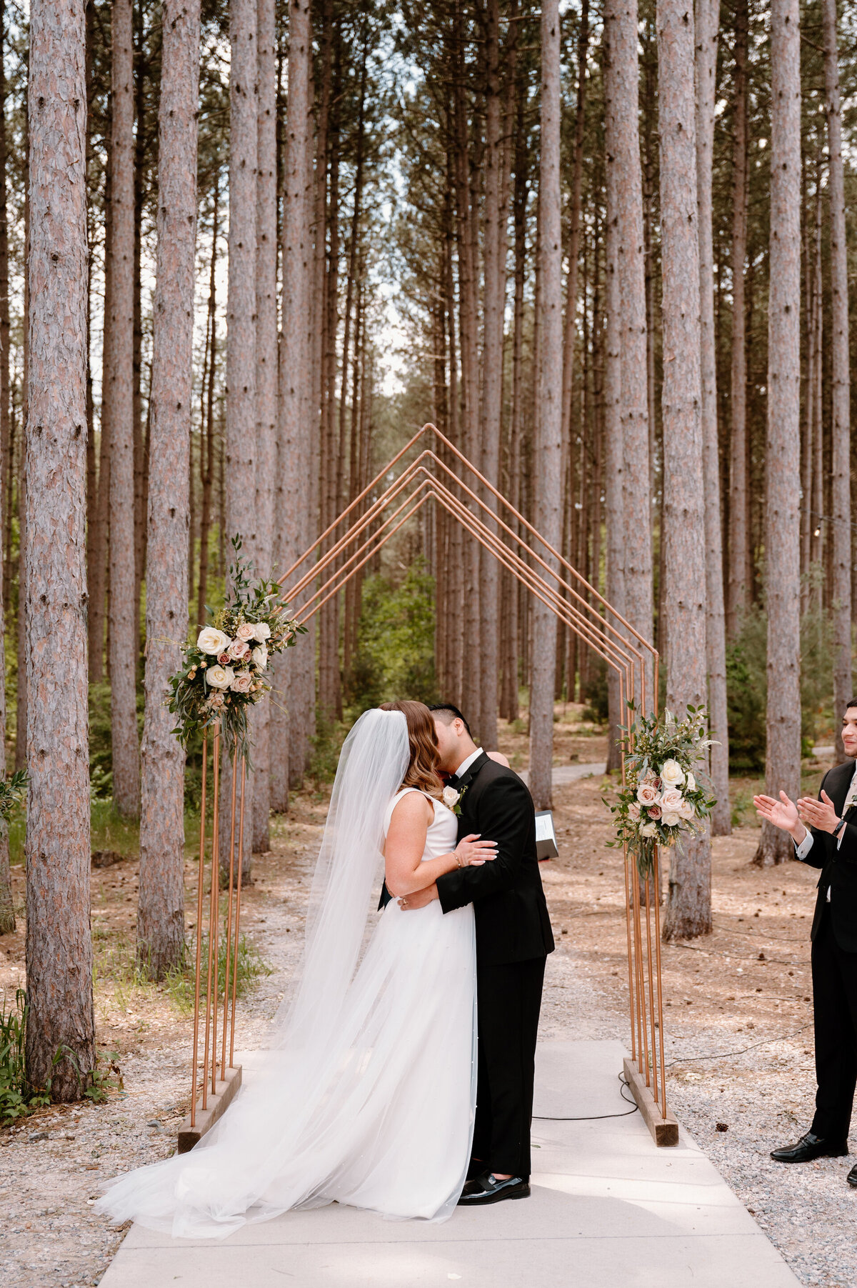 bride and groom standing at an altar in the woods