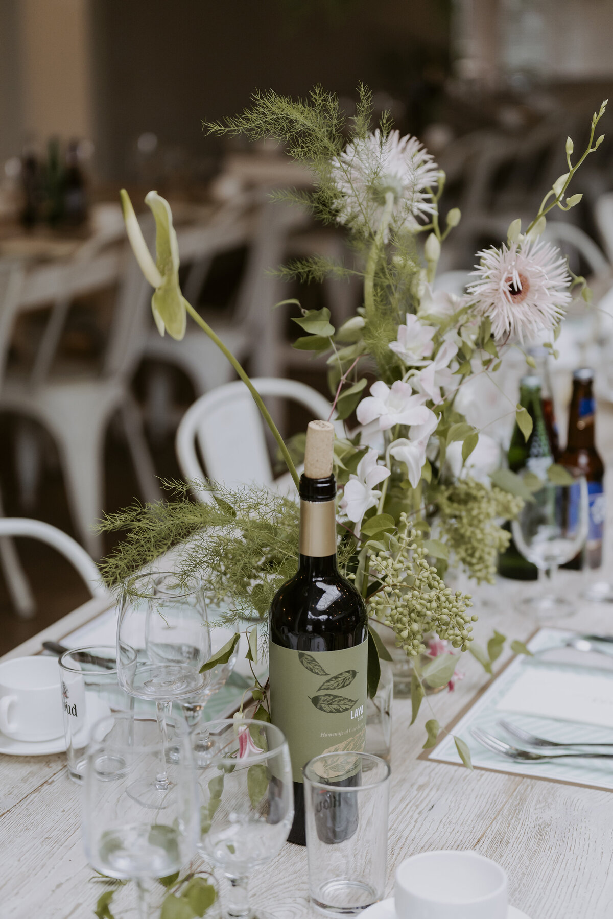 wedding table reception decorated by fresh flowers with wine bottle