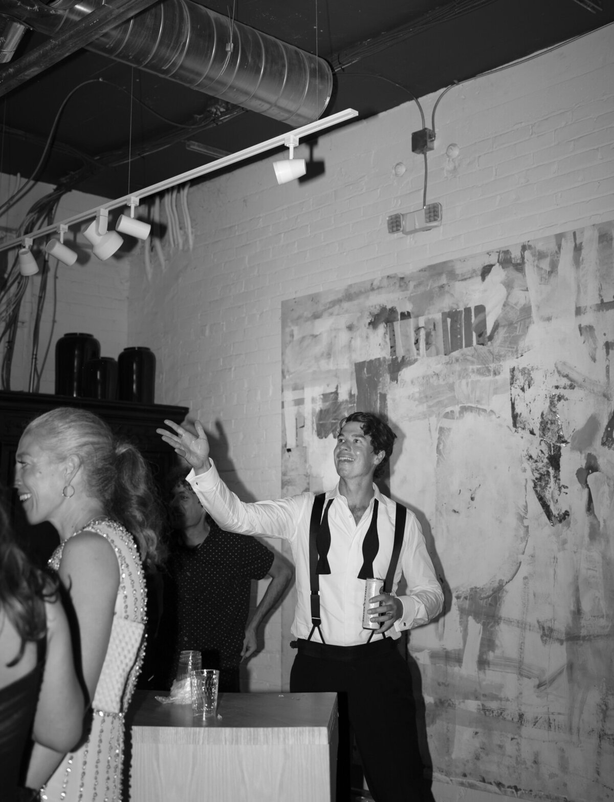 a groom throws a beer while bartending at his wedding afterparty in Detroit