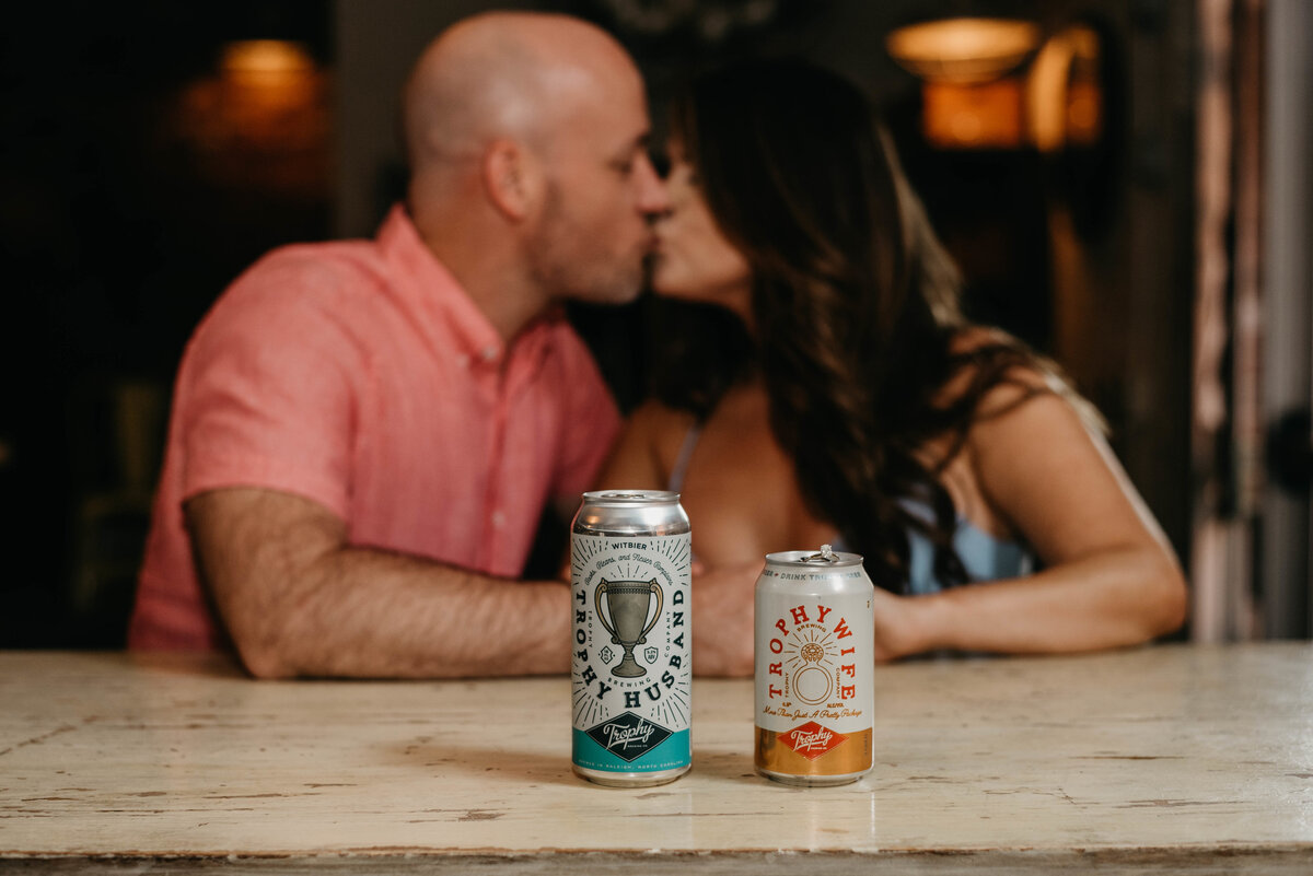 A couple kissing and sharing drinks