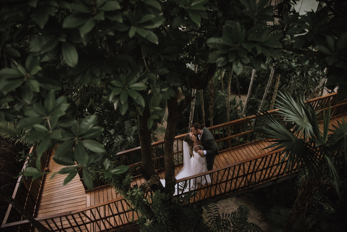 Couple goes for a kiss a their destination wedding at Villa Amaite in Tulum Mexico.