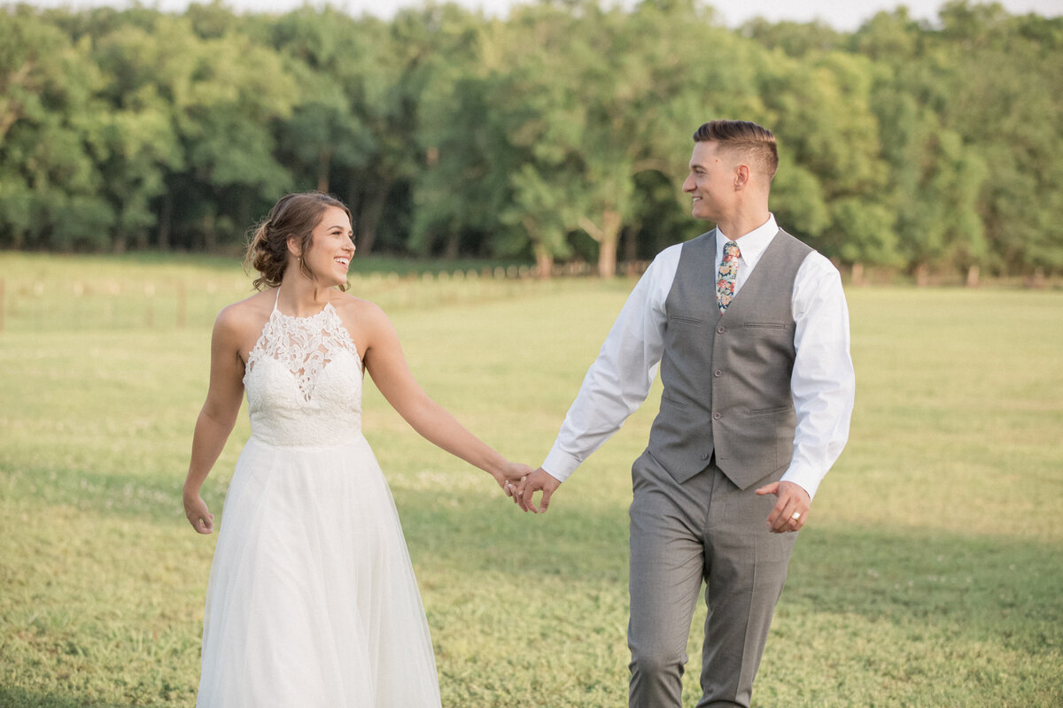A bride and groom gaze lovingly at each other during their golden hour session on their wedding day
