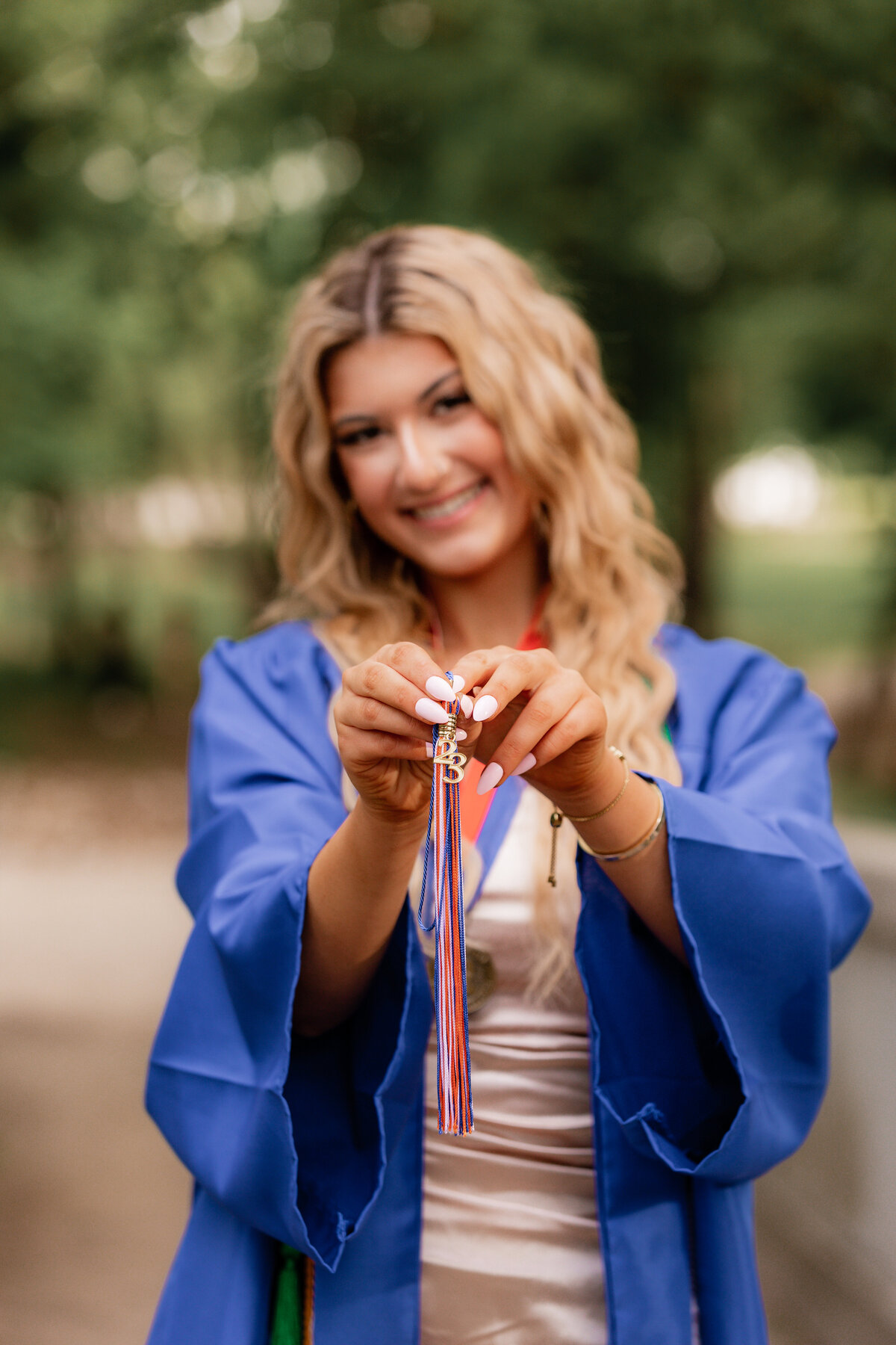 A blonde shows off her graduation tassle.