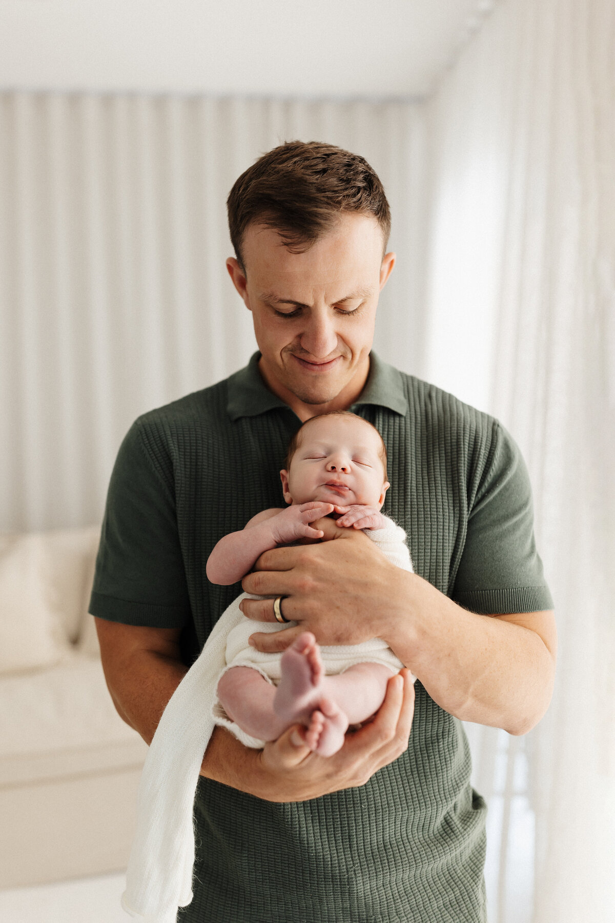 A father holding his newborn baby during a family photoshoot in lucy jane photography