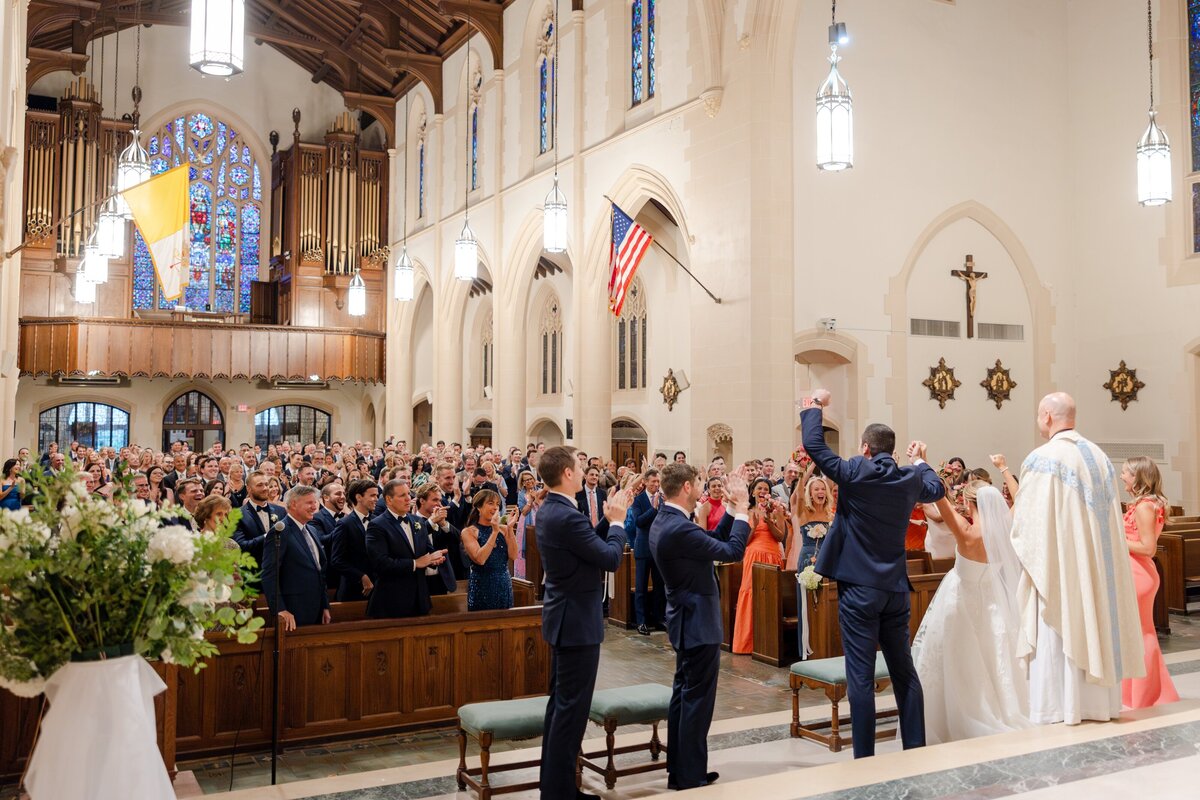 newlyweds cheered on by guests after mass ceremony
