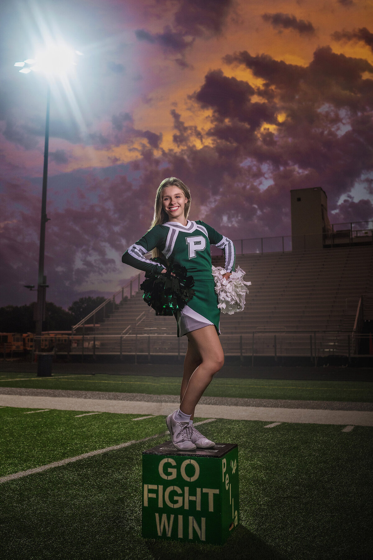 An image captured by an Iowa Senior Photographer of a cheerleader posing on a box