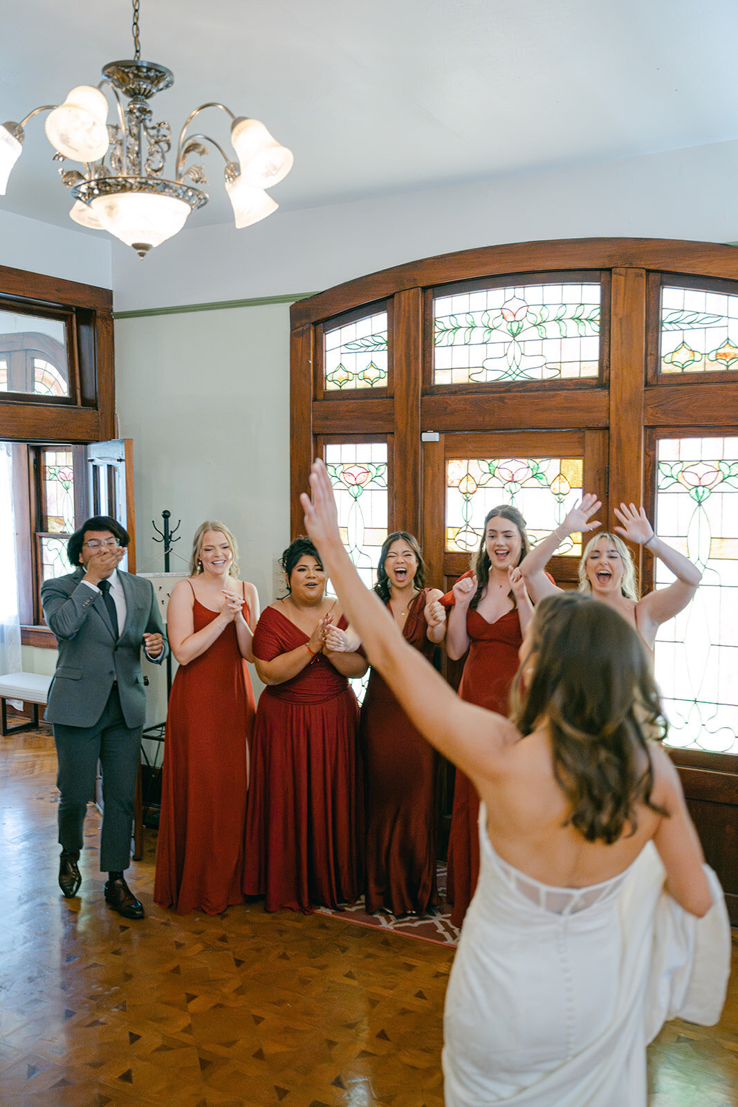 Fun editorial shot of bridesmaids toasting and cheering before wedding in San Antonio bridal suite