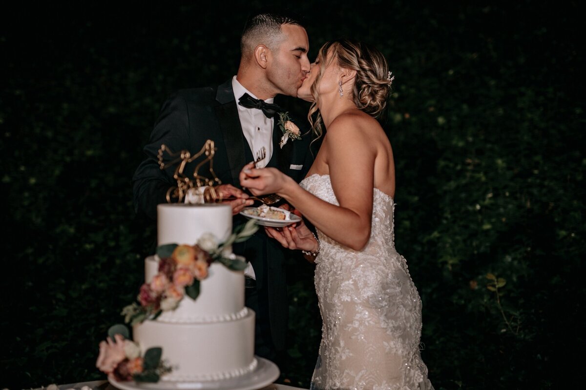 Bride and Groom kissing after having a bite of their wedding cake.