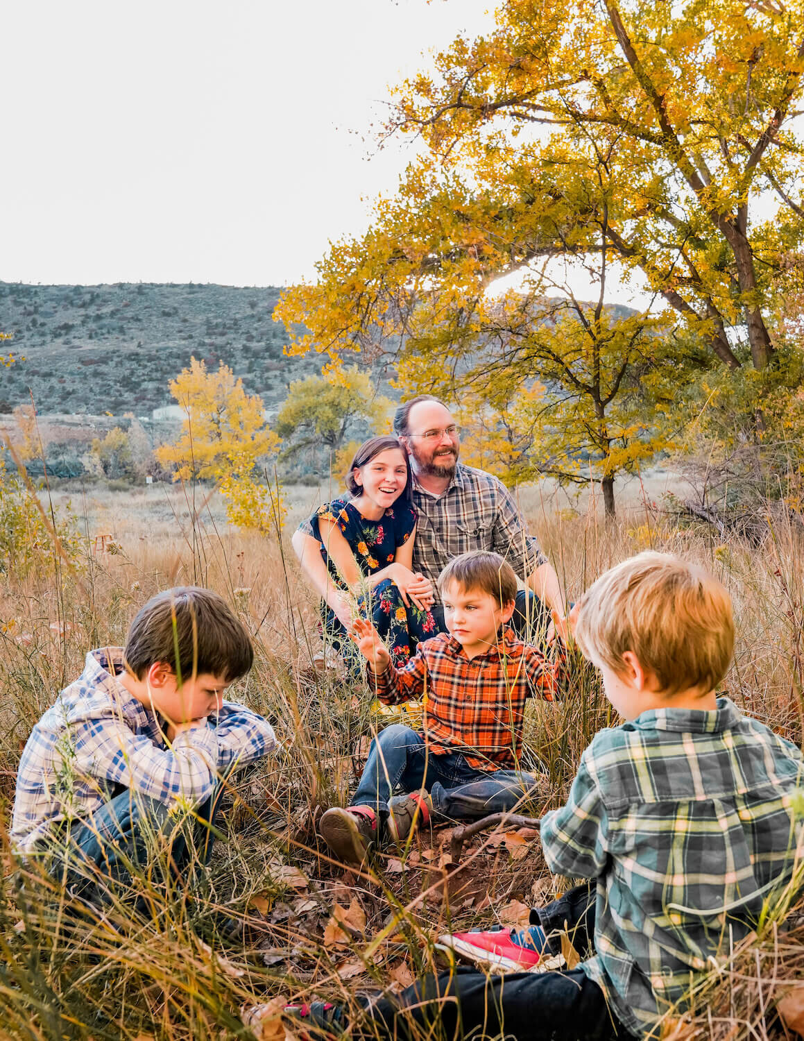 denver family photography - family sitting together in field