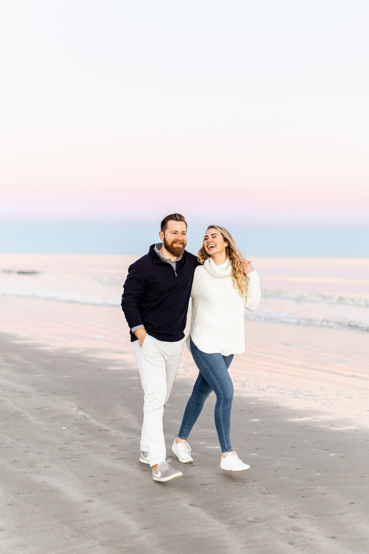 couple walking together on the beach by wedding photographer naples fl