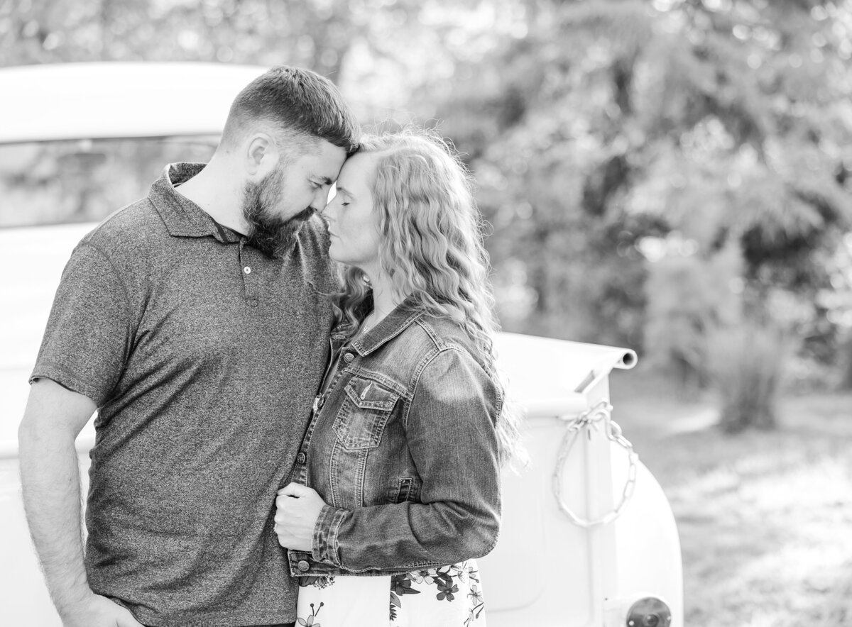Husband and wife with their heads together by a vintage truck for North East, PA, couple’s photography.