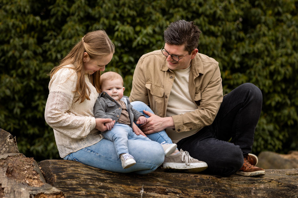 gezinsfoto ouders met baby op boomstam