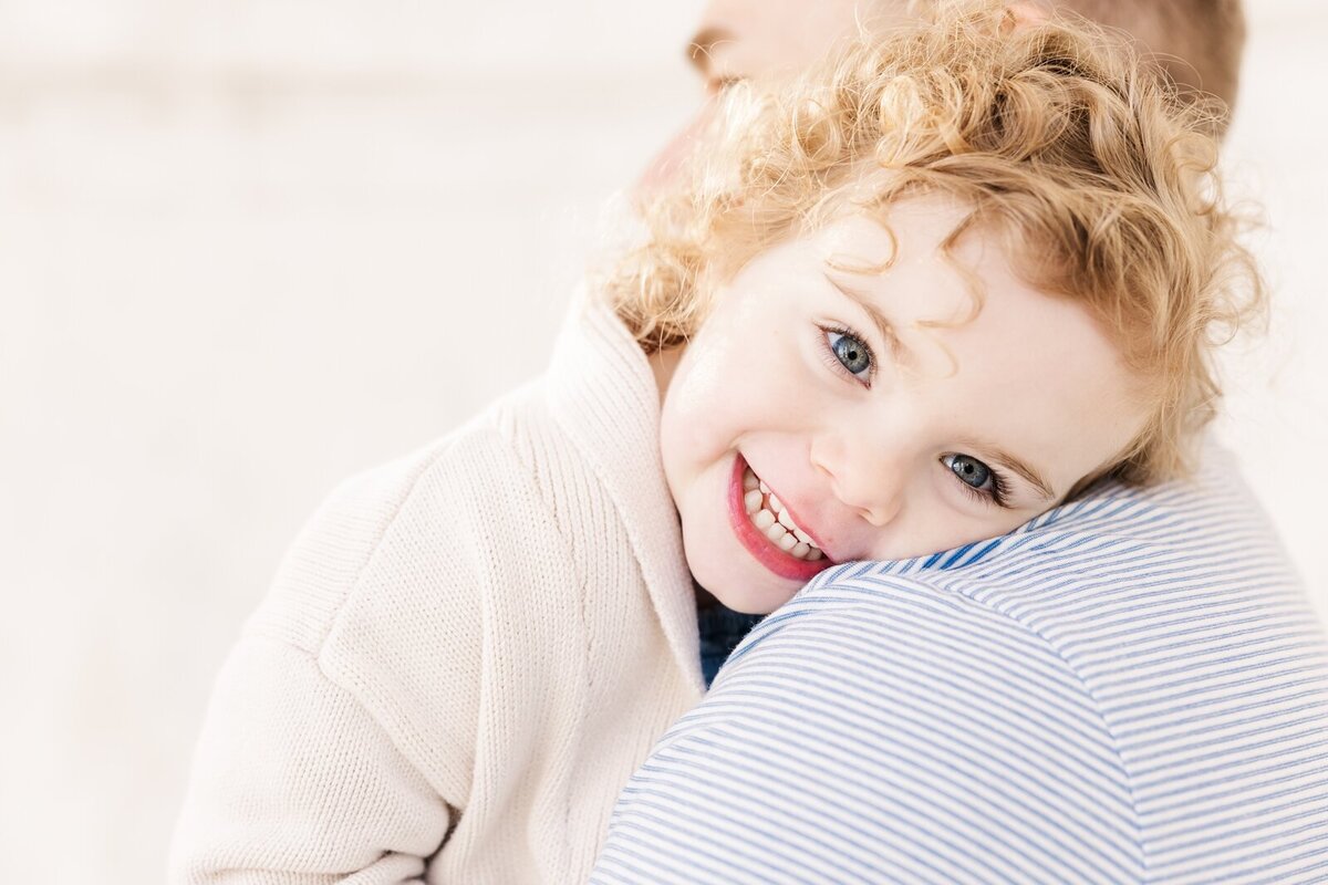 Little girl resting her head on her dad's shoulder by an Ohio family photographer