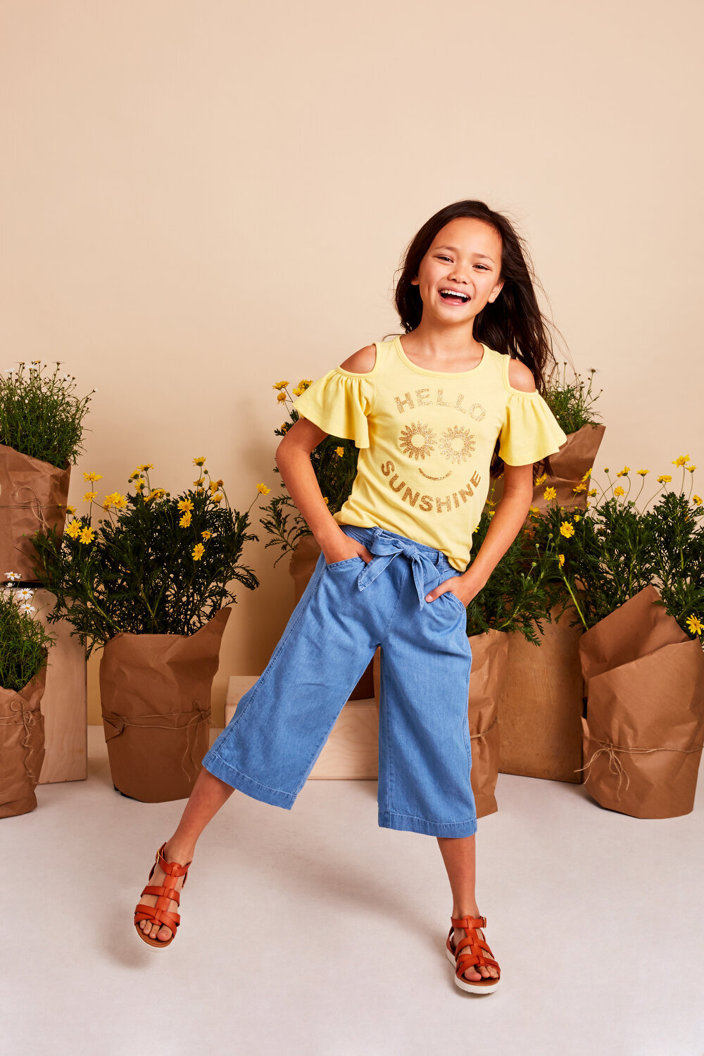 Greer Rivera Photography Kids Editorial Photoshoots Marin CA Girl standing on 1 foot smiling with flowers behind her