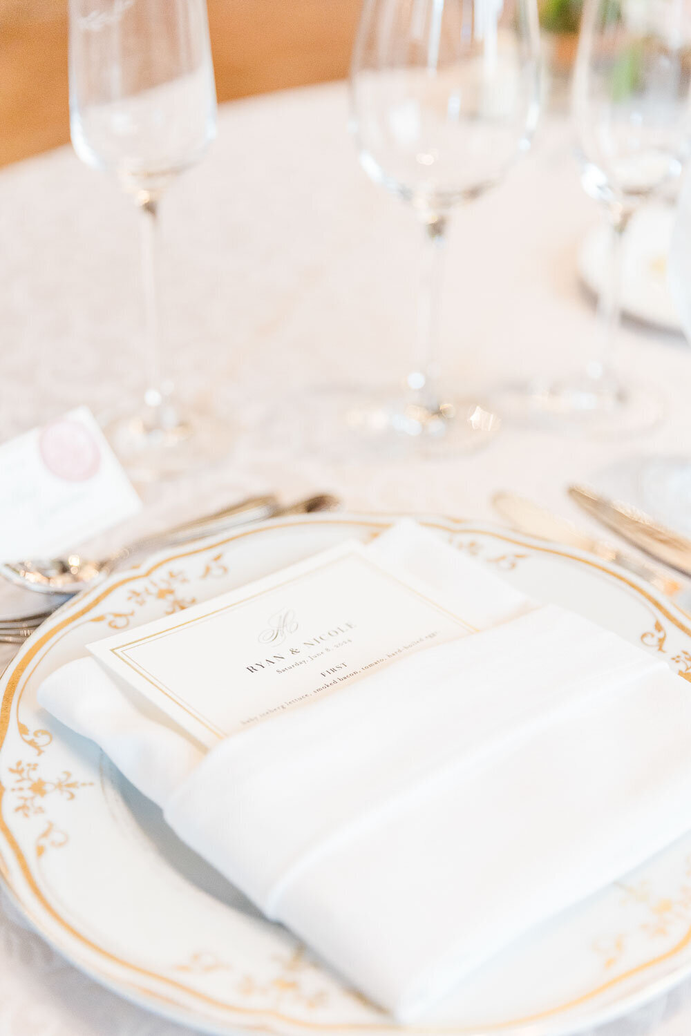 Elegant place setting with gold-rimmed plate and menu.