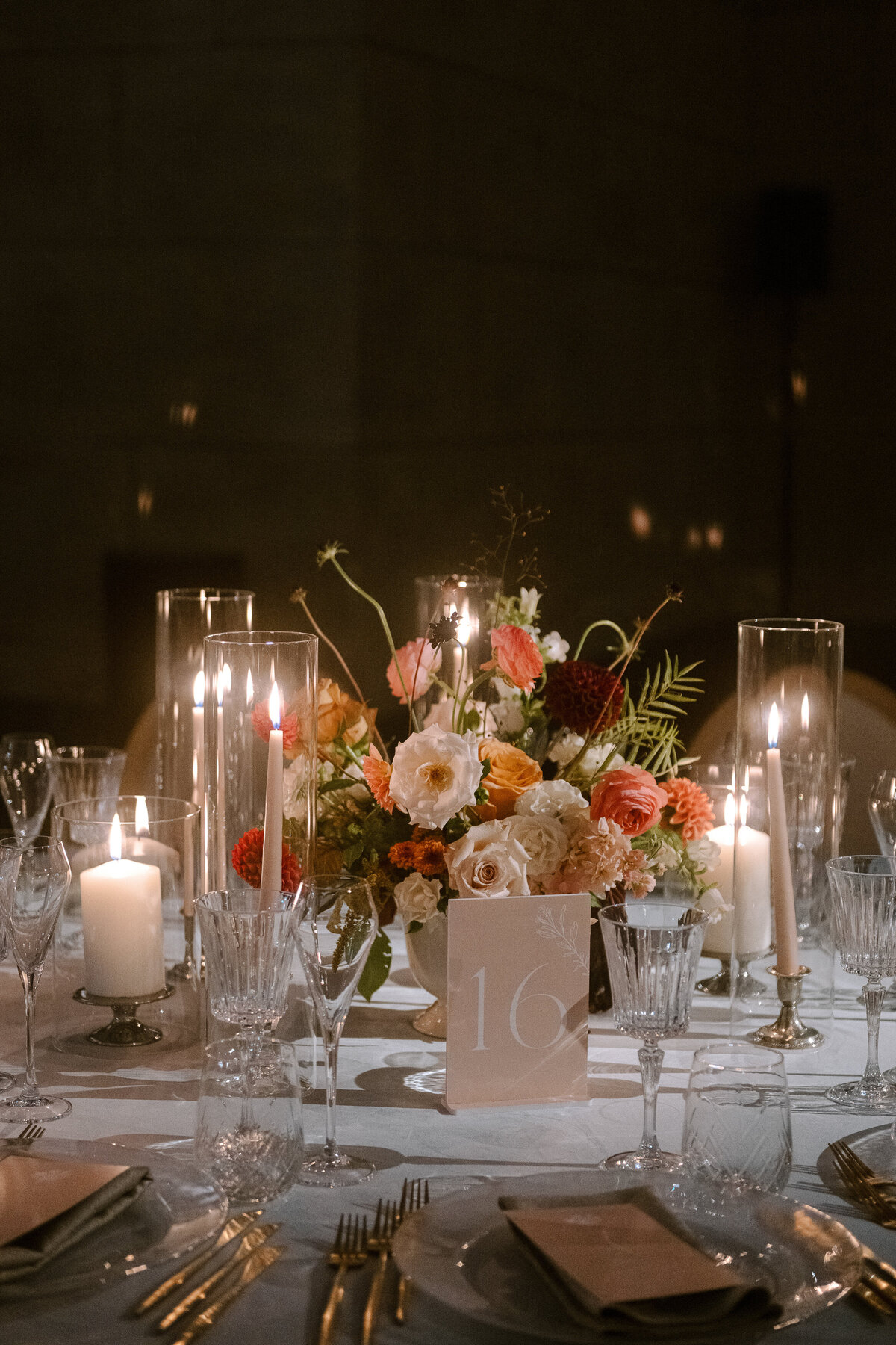 An intimate table at a Four Seasons wedding reception decorated with candles and a colourful centrepiece.