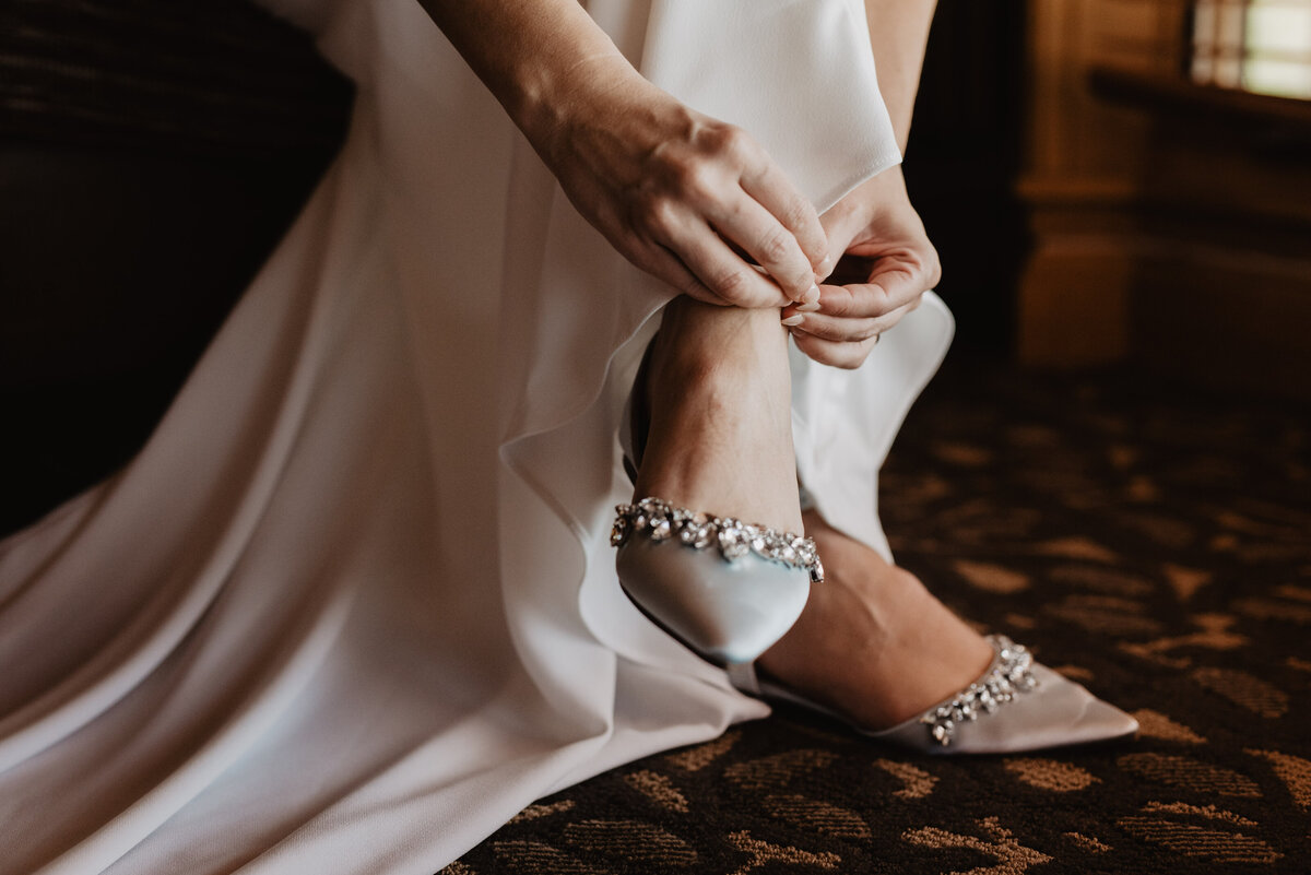 Photographers Jackson Hole capture bride putting on bridal shoes