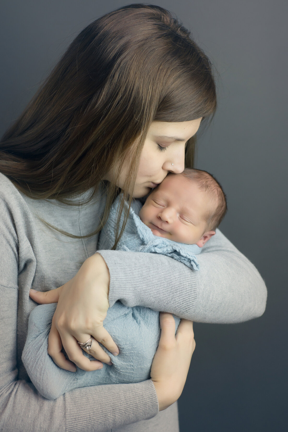 Newborn baby boy with mother kissing head in Kennebunk Maine