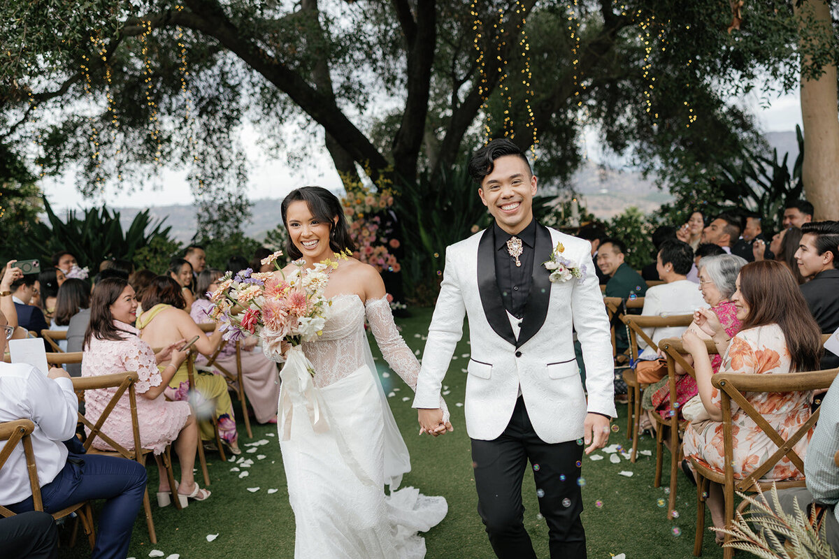 Bride and groom walking down the aisle during their ceremony exit at Loft Lucia in Chicago, surrounded by cheering guests, captured by Chicago wedding photographer Abe Fernandez in a candid, documentary style