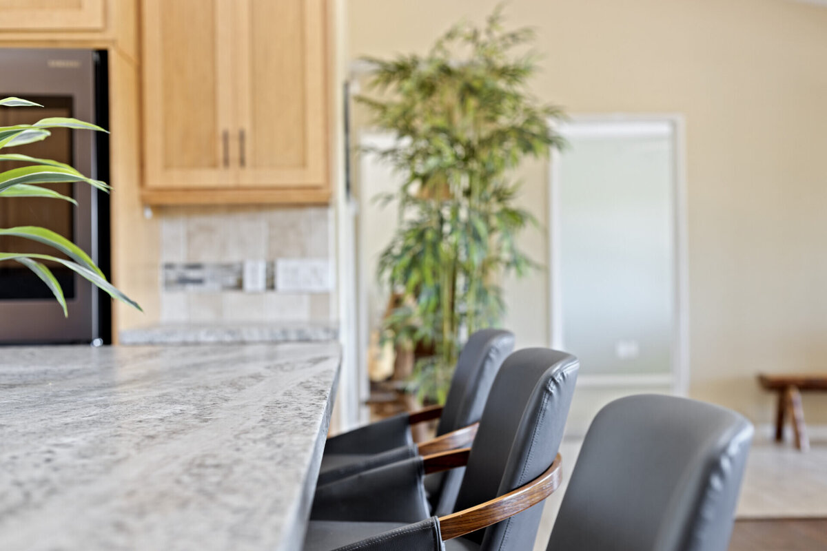 Tight shot of blue stools and kitchen counter. Traditional living and dining room. Real Estate home in Ramona
