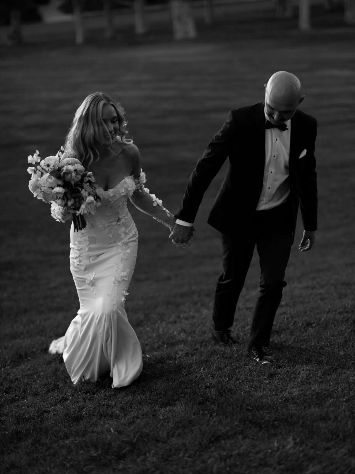 bride and groom walking along holding hands at Muckenthaler Mansion Wedding