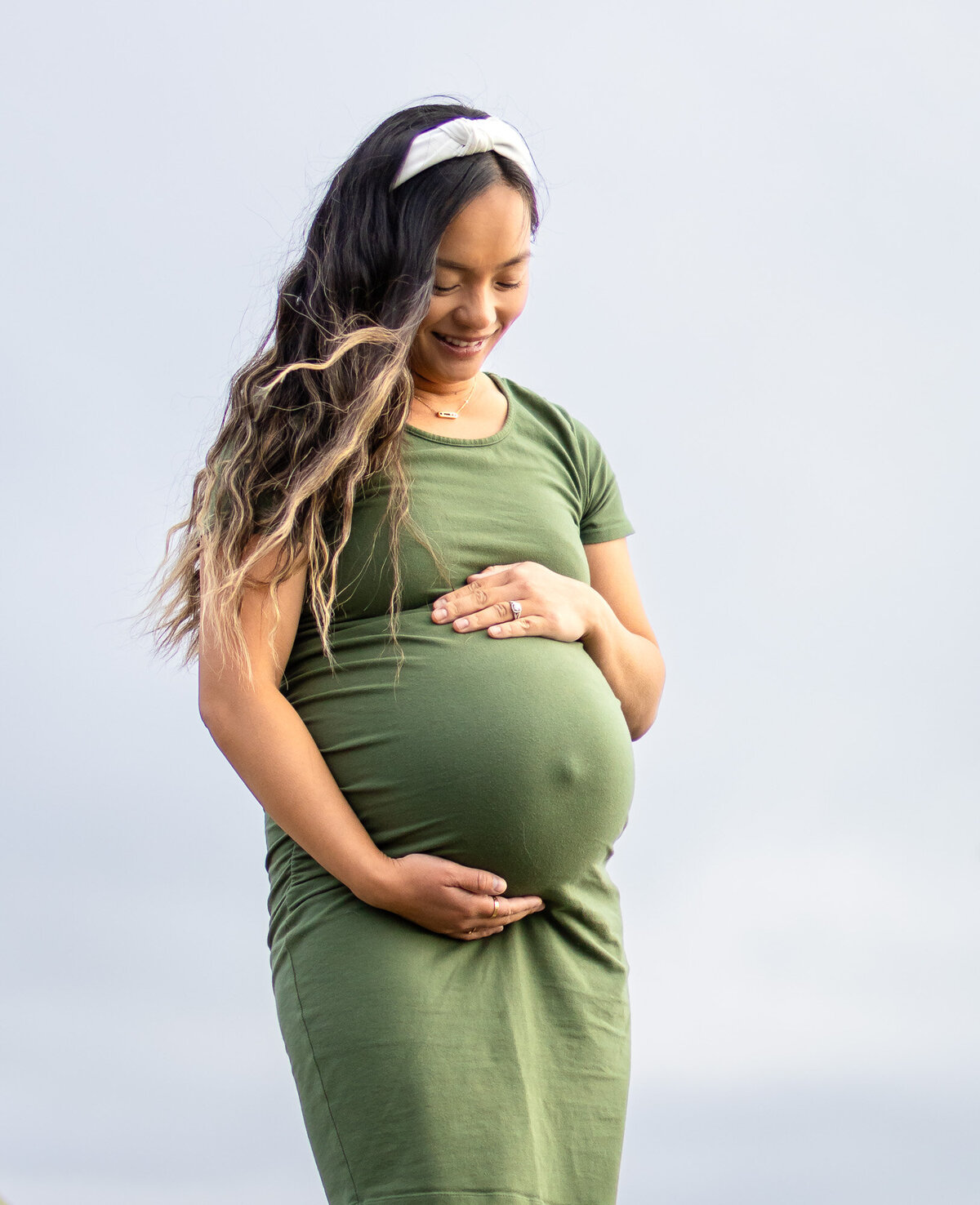 Smiling pregnant woman in green dress cradling her belly outdoors — Bay Area Maternity Portfolio - Ellobelle Photography Family Photographer