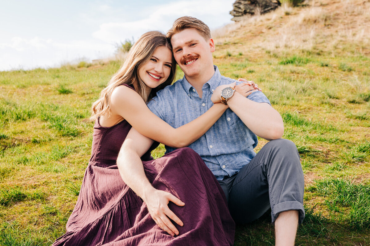 Engagement photo couple sitting together on lawn