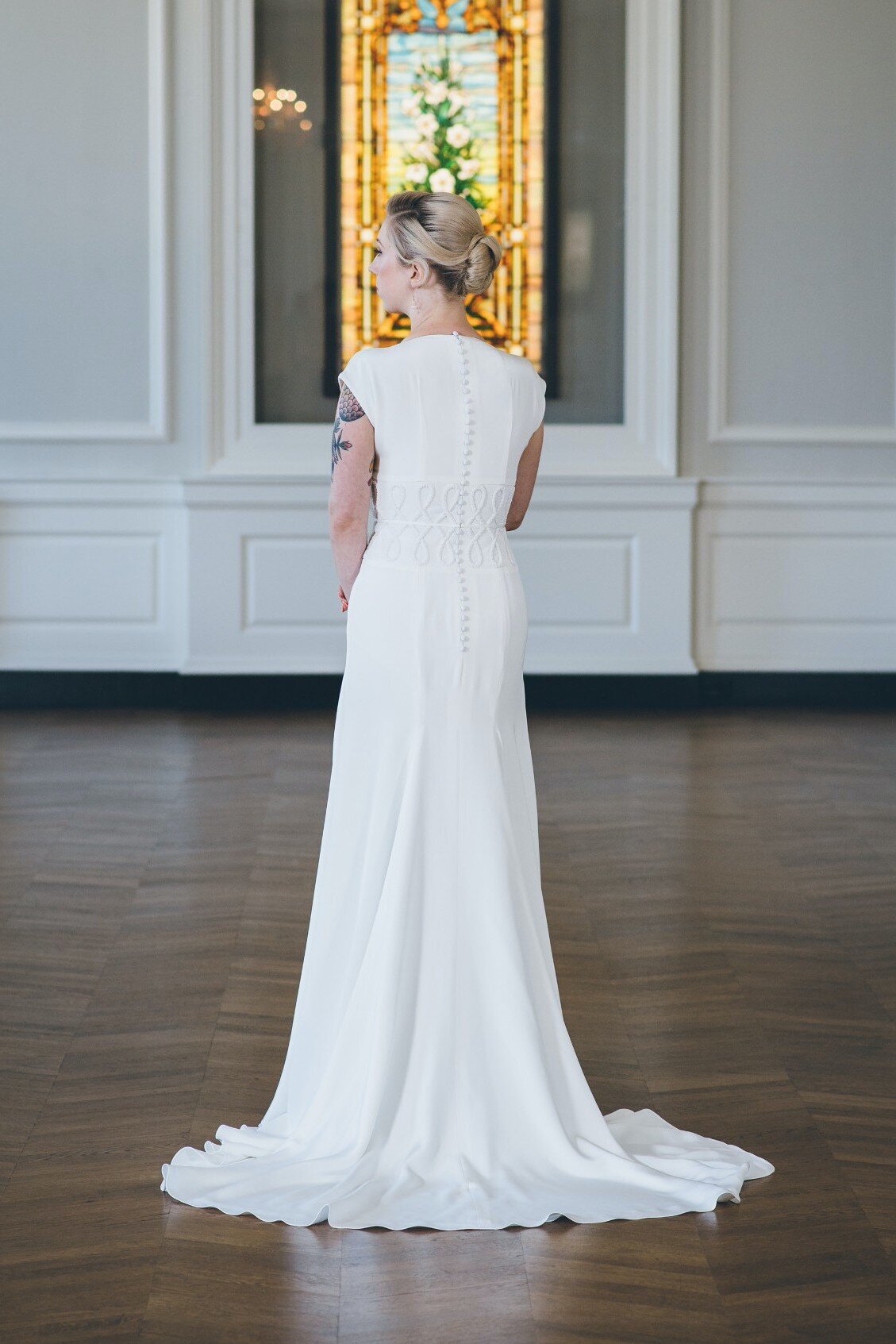 Anila's high back makes her a more modest wedding gown style. A line of fabric-covered buttons goes down from the neckline to the bottom of the zipper.