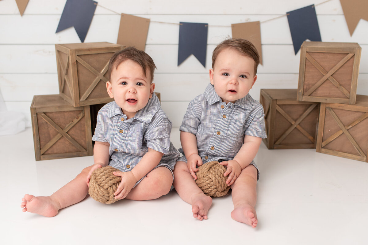 Twin boys smiling at the camera at twin photo session