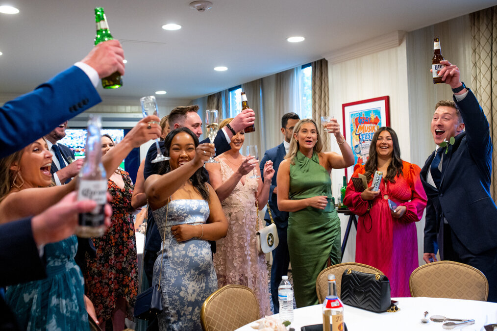 A group of people toasting at a wedding reception.