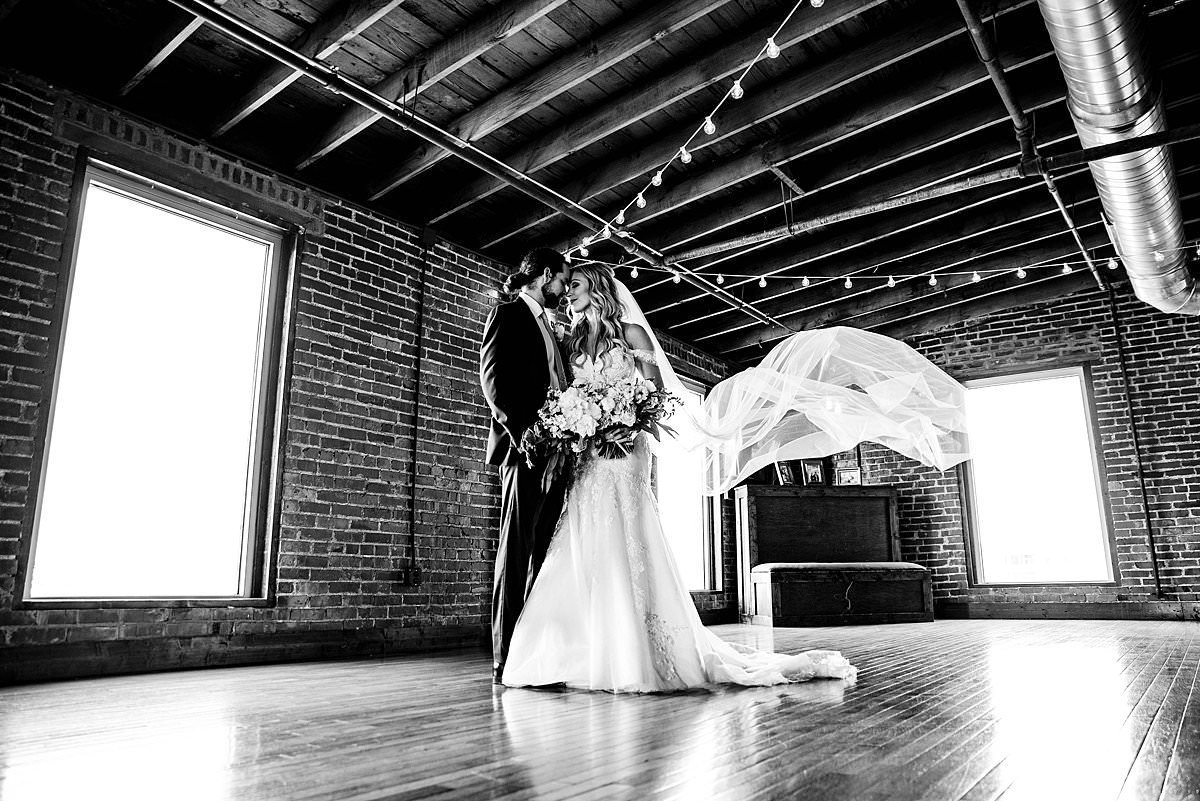 Black and white portrait of couple cozied together inside historic downtown Nashville building
