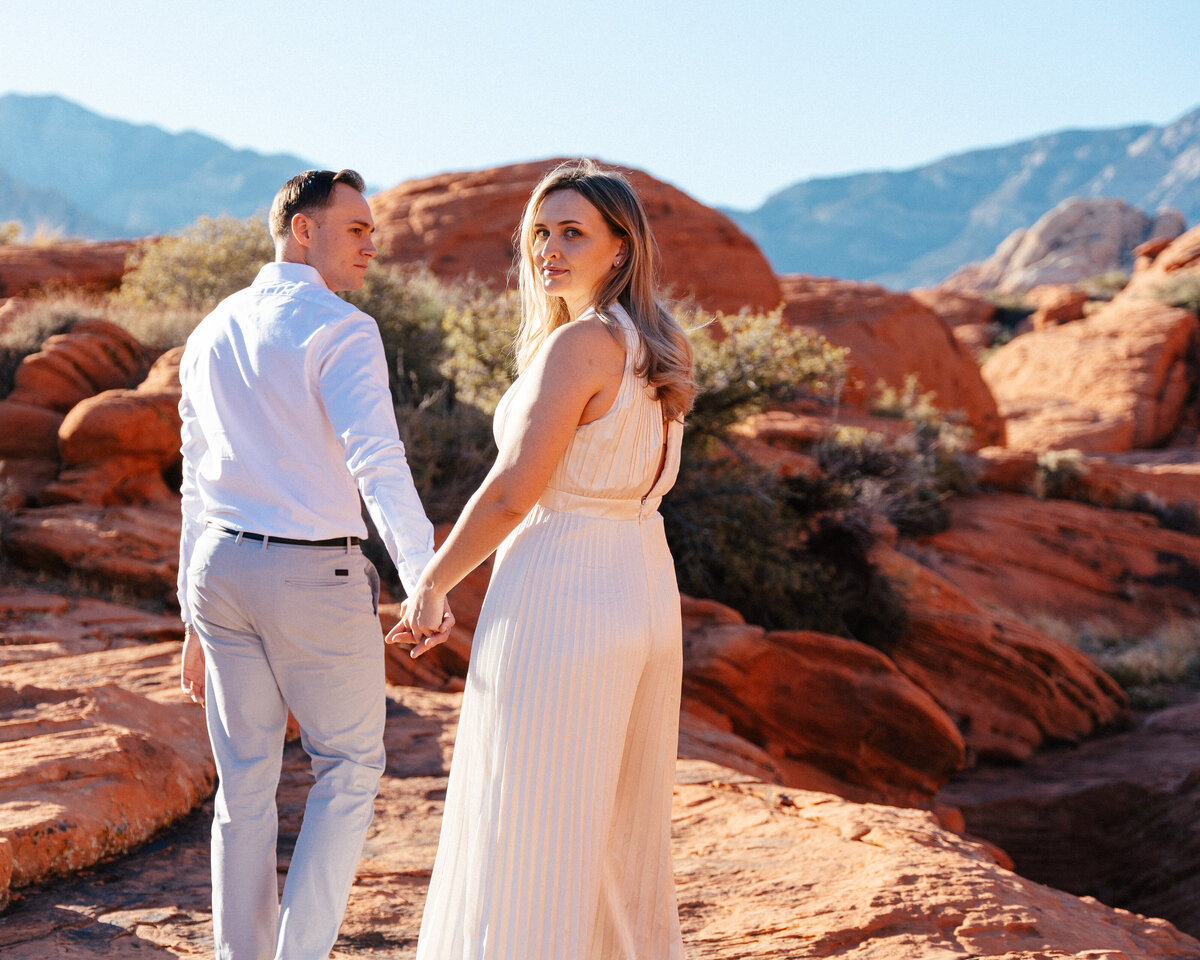 couple looking back at the camera in red rock canyon, nevada