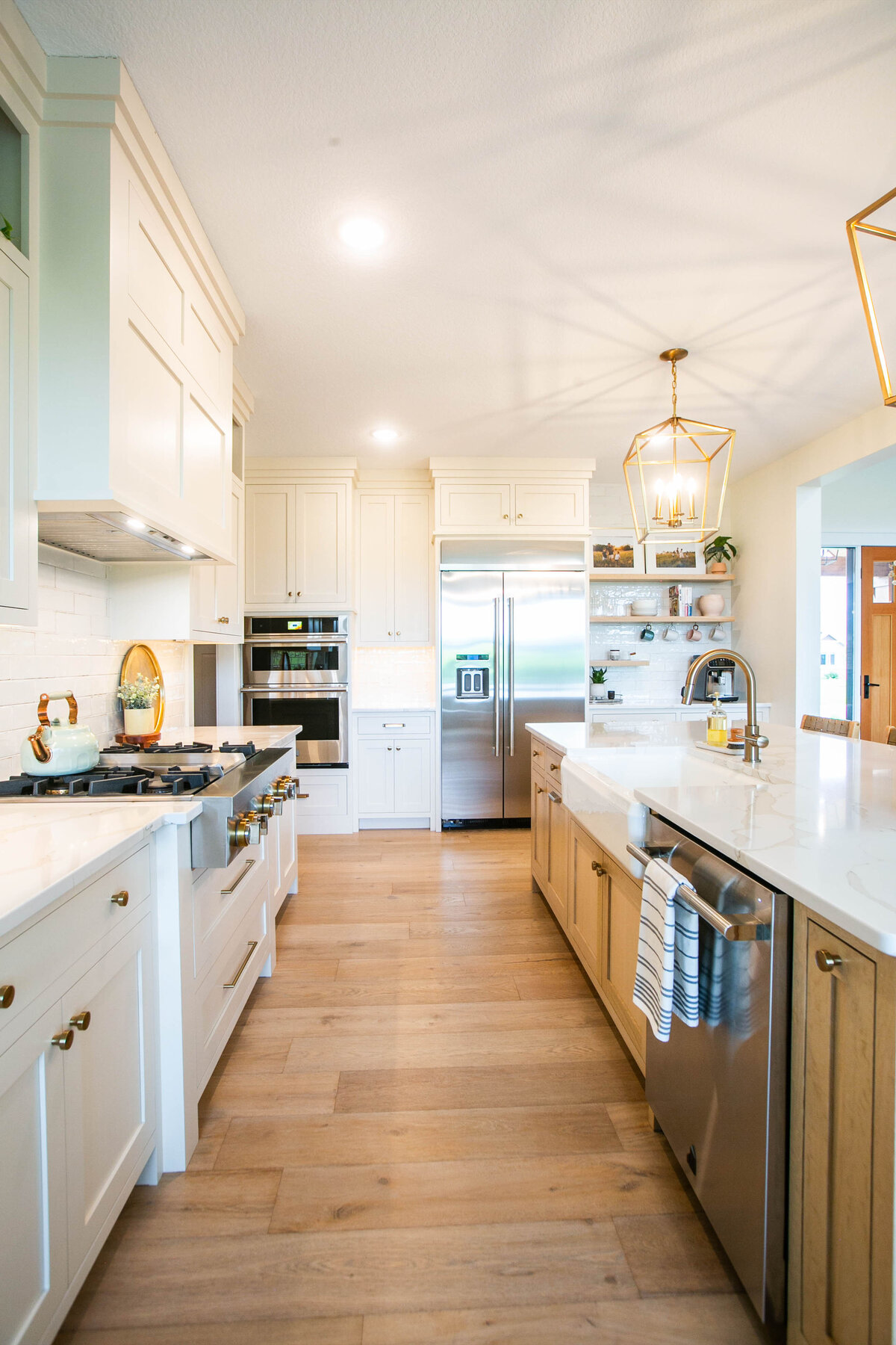 Open kitchen with white cabinets, large island, and quartz countertops in an Otsego custom home
