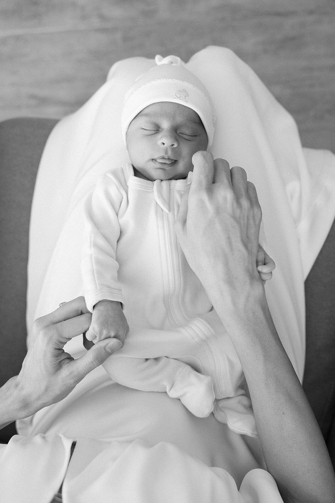 A peaceful black-and-white portrait of a sleeping newborn in soft baby clothing, captured during a Florida Keys family session.