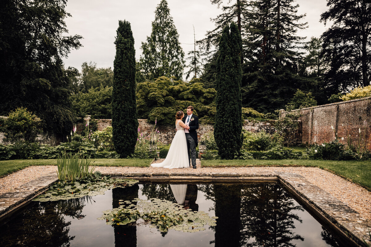 Couple taking wedding portraits in front of reflection pool