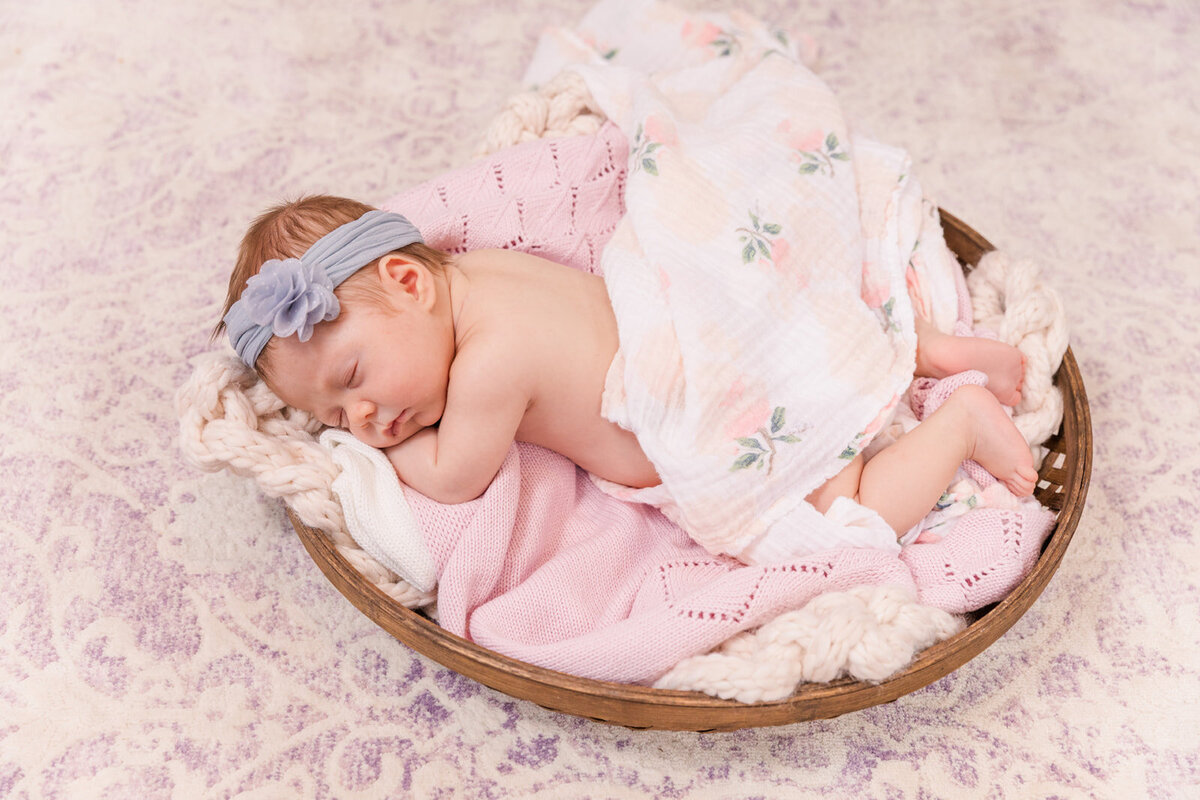 newbor baby girl sleeping in a basket