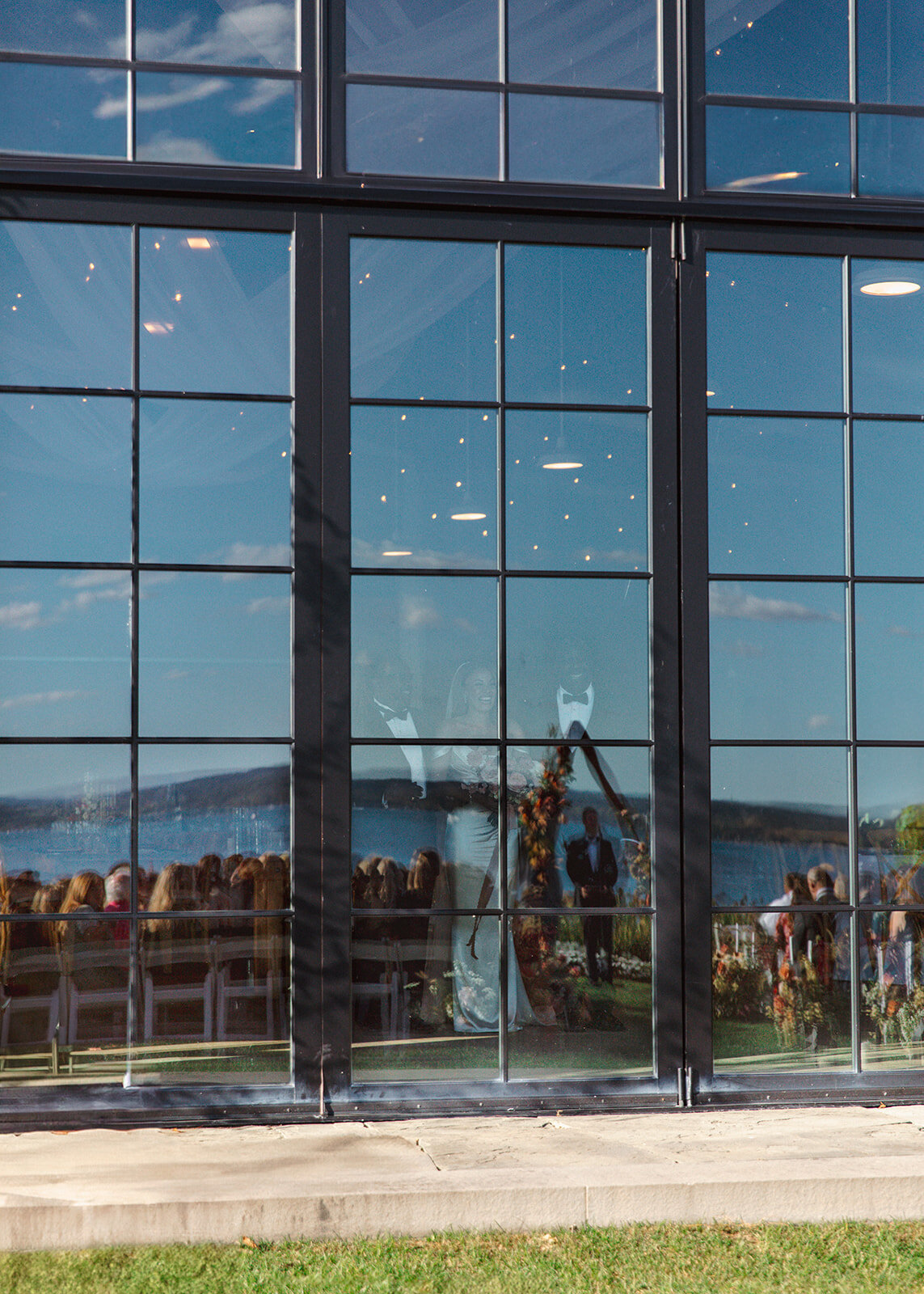 The bride prepares to walk down the aisle as her guests sit on the lawn at The Lake House on Canandaigua