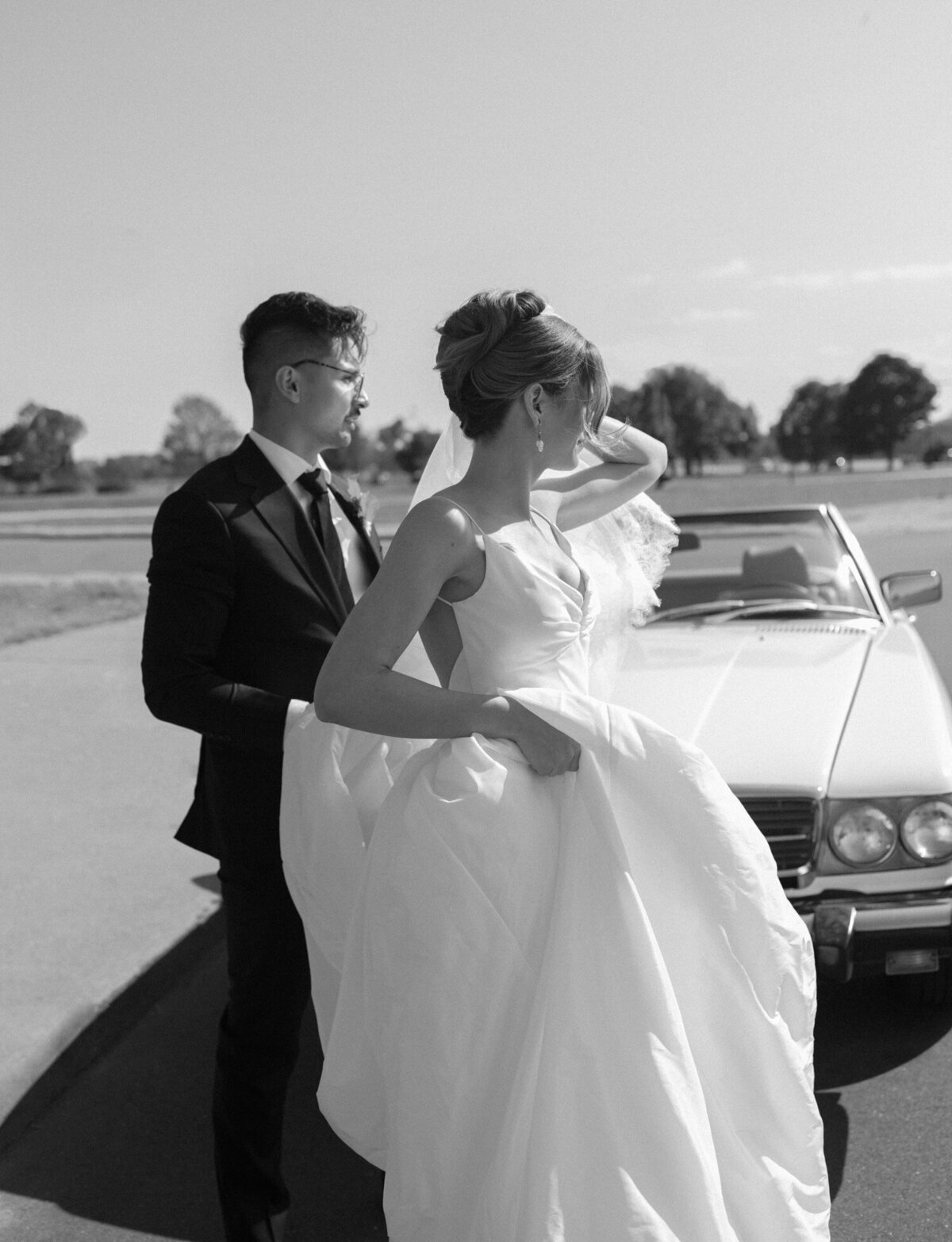 unique, natural Detroit wedding photography shows a newlywed couple with their vintage mercedes convertible wedding car
