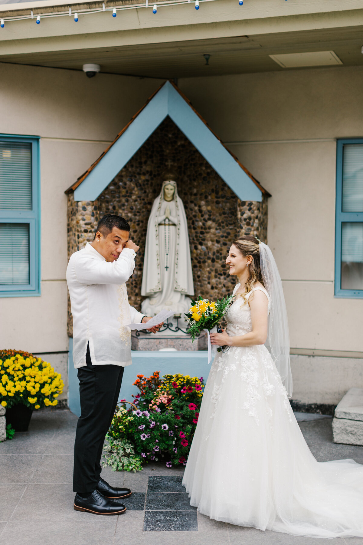 Emotional groom reading vows in front of bride