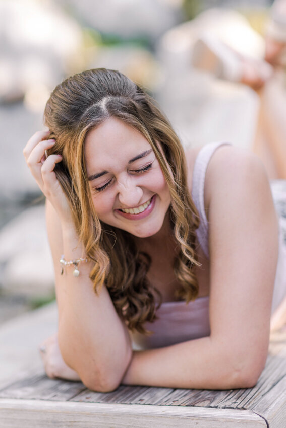 teen girl laying on stomach and laughing