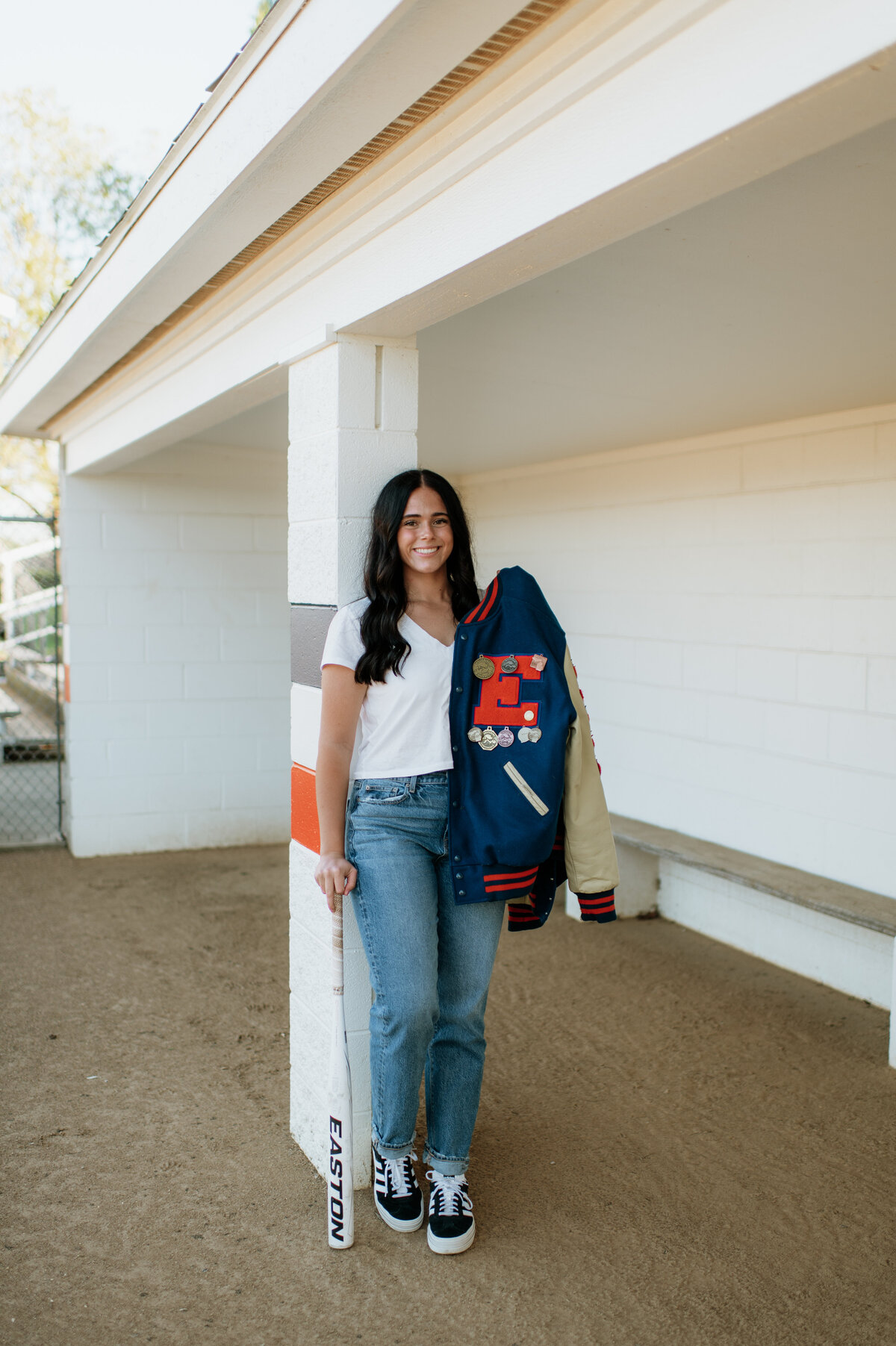 Senior portraits holding varsity jacket Indiana