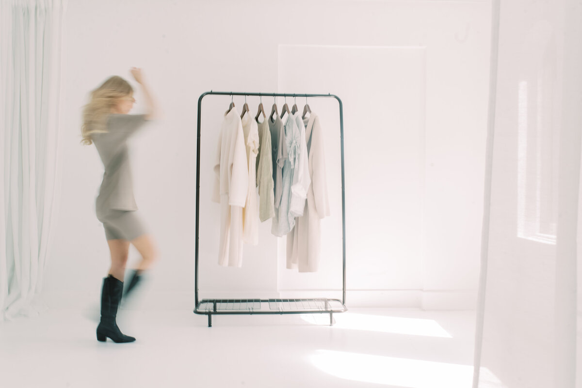 Charly Goss In a studio in Oakville dancing in front of a clothing rack