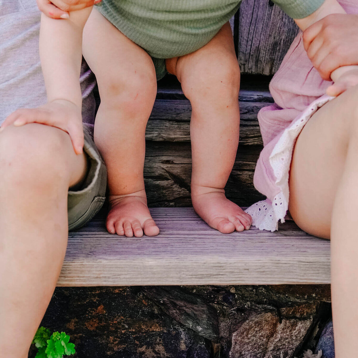 toddler standing between parents