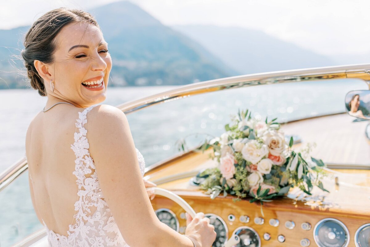 Brud som skrattar och kör en Rivabåt på Comosjön