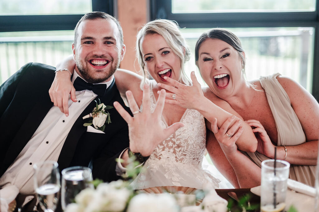 Showing off their ring with big smiles.