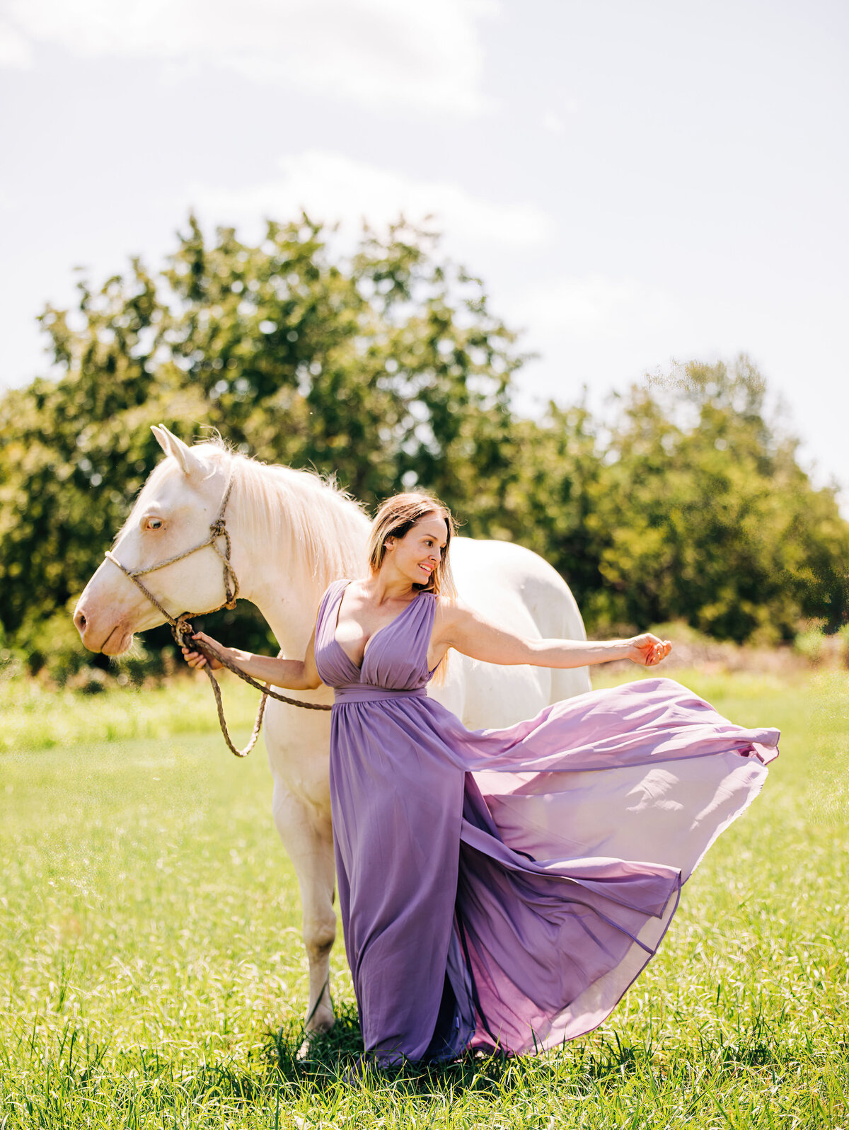 girl in purple dress with cremello horse